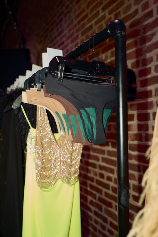 Huha Seamless Thongs hang next do dresses and furs backstage at the LAPOINTE SS26 fashion show